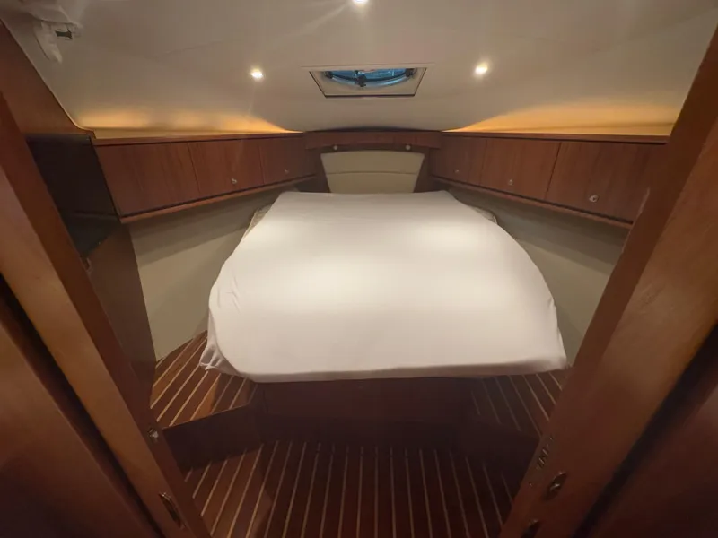 Slide: The Image of Luxurious cabin interior of 2011 Tiara Yachts 3900 Sovran with wood paneling and cozy bed. - 18