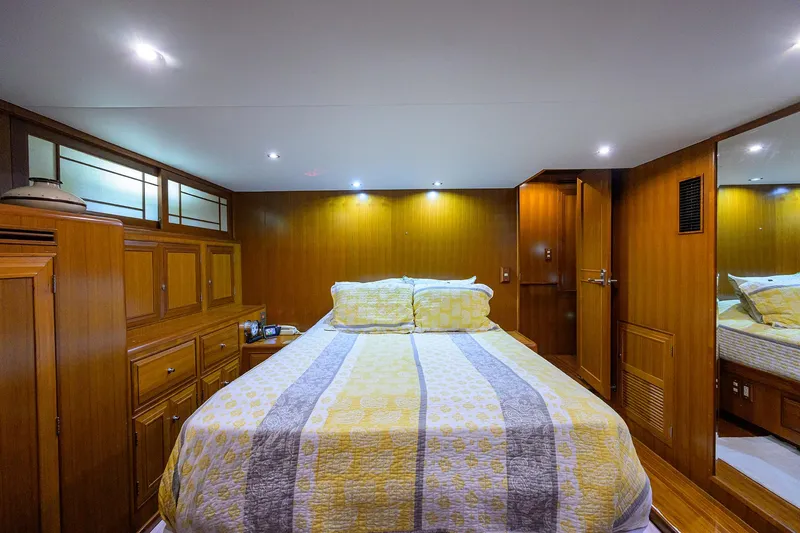 Slide: The Image of Luxurious bedroom interior of 2001 Ocean Alexander 602 yacht with wood paneling and cozy bedding. - 10