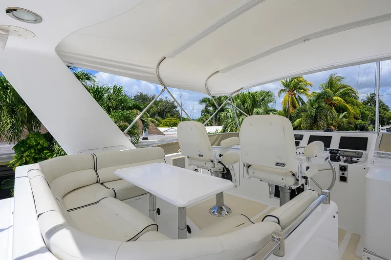 Slide: The Image of Luxurious 2001 Ocean Alexander 602 yacht interior with white seating and helm, surrounded by tropical scenery. - 29