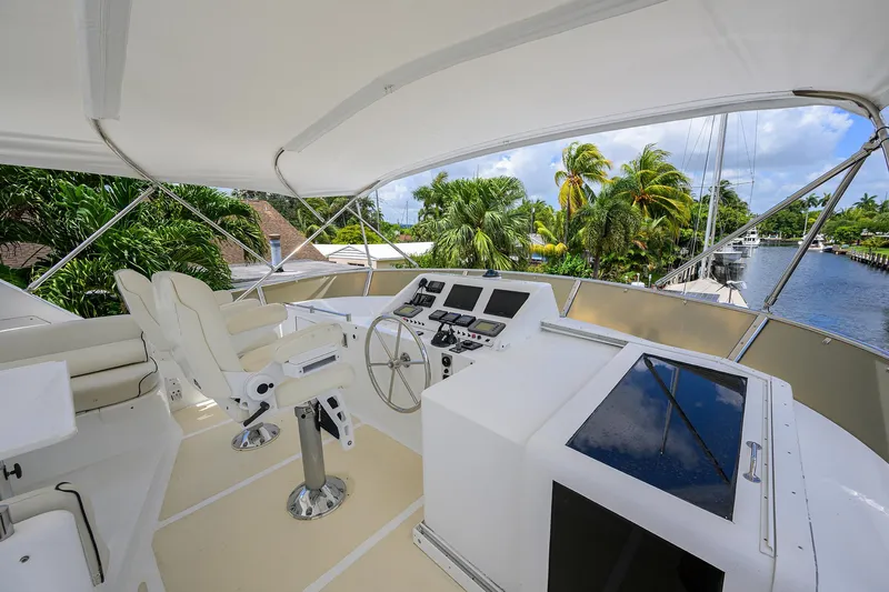 Slide: The Image of Flybridge of 2001 Ocean Alexander 602 yacht with helm station and seating, surrounded by tropical scenery. - 30
