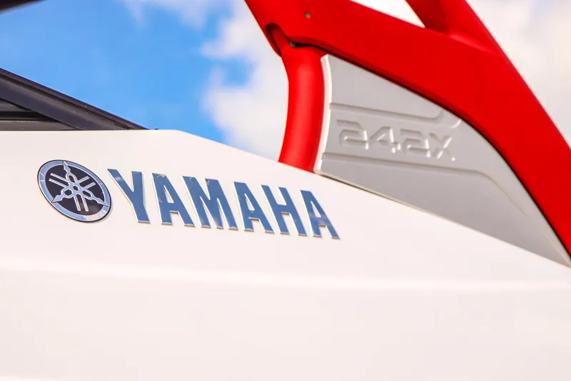 Slide: The Image of 2019 Yamaha Boats 242X E-Series logo with red and white design against blue sky. - 31