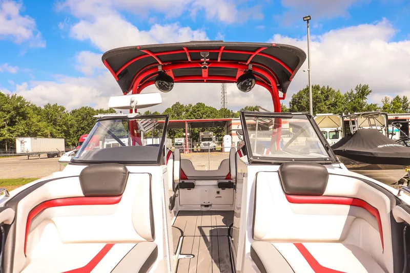 Slide: The Image of 2019 Yamaha Boats 242X E-Series interior with red accents, parked outdoors under blue sky. - 8