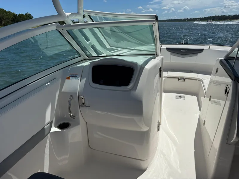 Slide: The Image of 2021 Robalo R247 boat interior with open deck, glass windshield, and ocean view. - 10