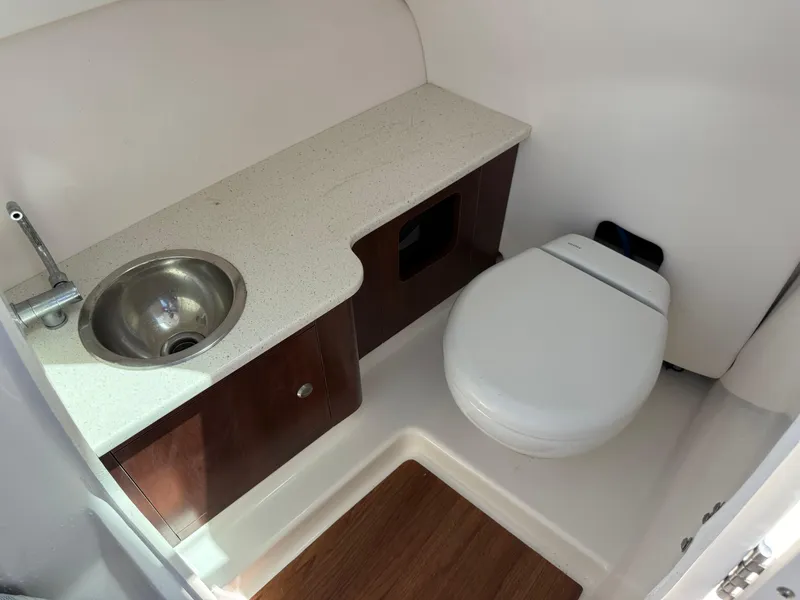 Slide: The Image of 2021 Robalo R247 boat bathroom with sink, countertop, and toilet. - 11