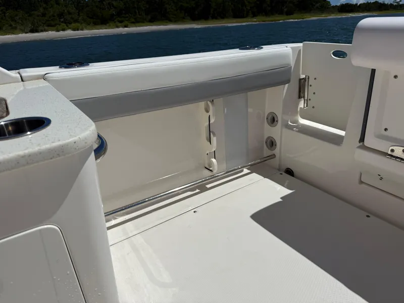 Slide: The Image of 2021 Robalo R247 boat interior with seating and storage, near water. - 17