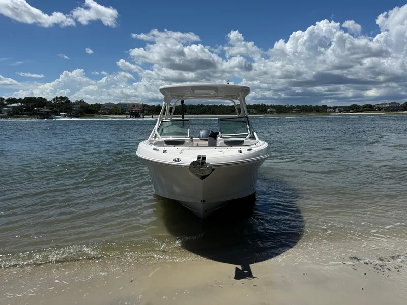 Slide: The Image of 2021 Robalo R247 boat on sandy shore under blue sky with clouds. - 23