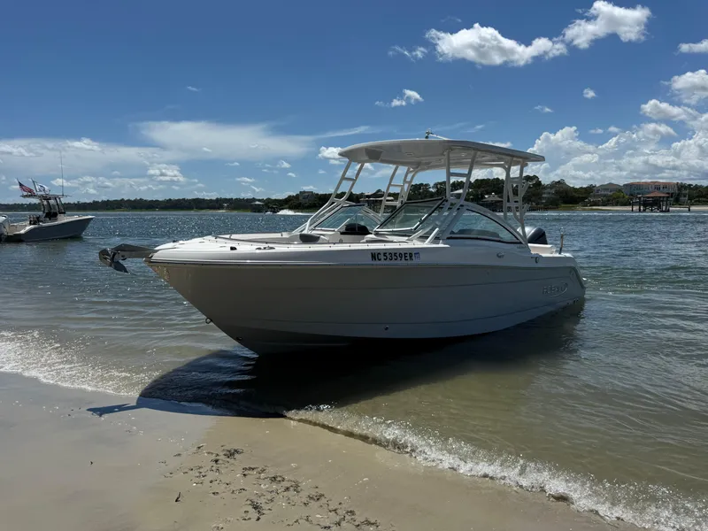 Slide: The Image of 2021 Robalo R247 boat anchored on sandy beach under clear blue sky. - 24