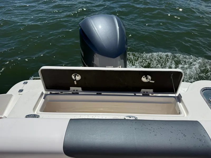 Slide: The Image of 2021 Robalo R247 boat with open storage compartment and Yamaha outboard motor on water. - 25