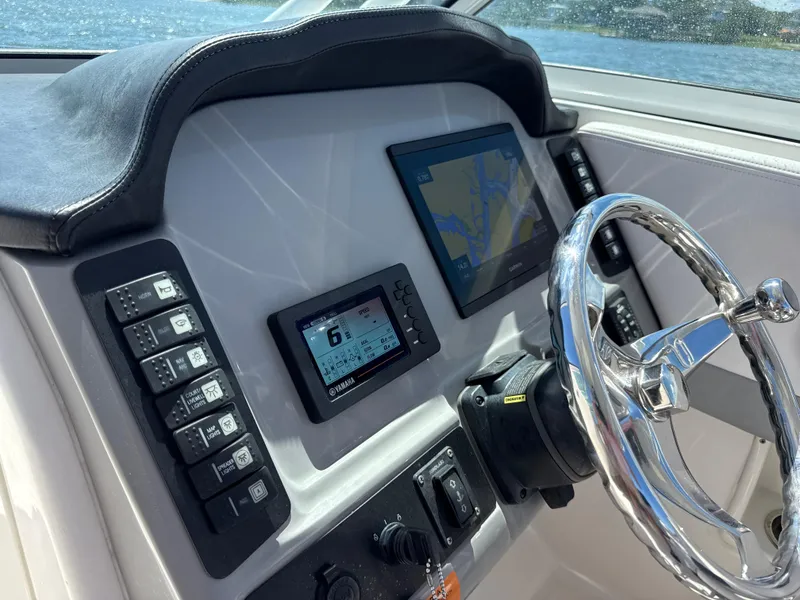 Slide: The Image of 2021 Robalo R247 boat dashboard with steering wheel, digital displays, and control switches. - 6