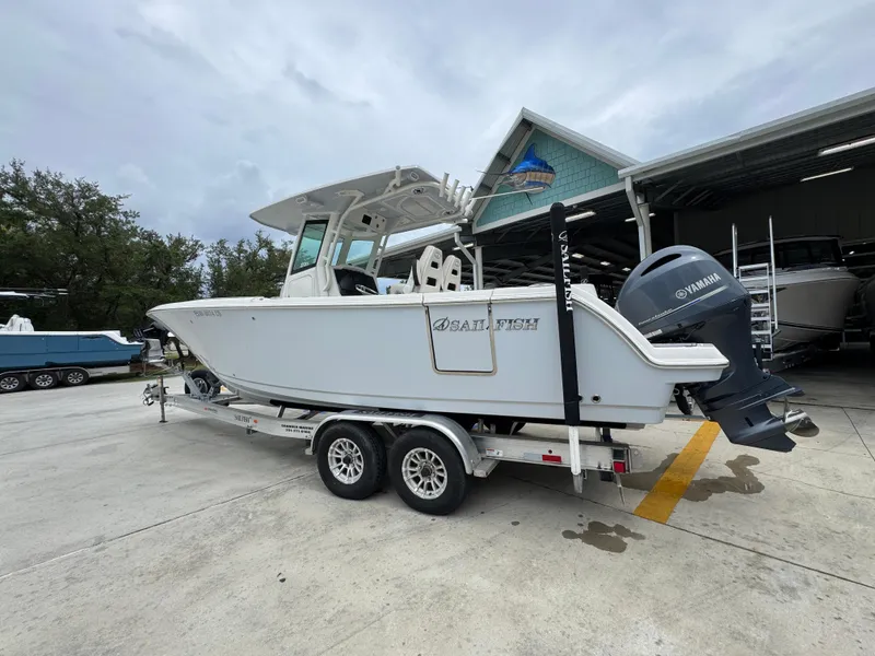 Slide: The Image of 2022 Sailfish 272 CC boat on trailer, parked outside a marine dealership. - 16