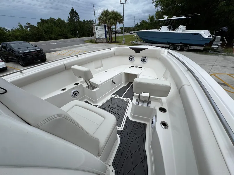 Slide: The Image of 2022 Sailfish 272 CC boat interior with seating and speakers, parked near a road. - 17
