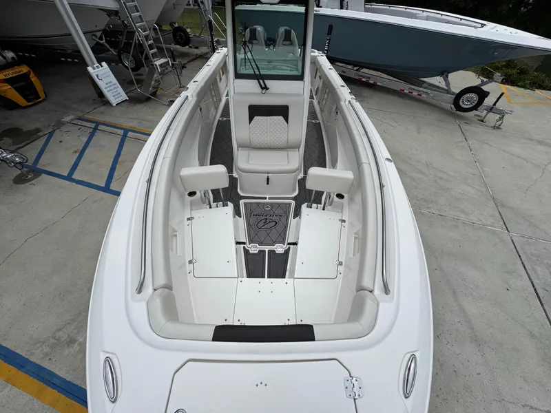 Slide: The Image of 2022 Sailfish 272 CC boat interior with seating and storage, displayed on a concrete lot. - 20
