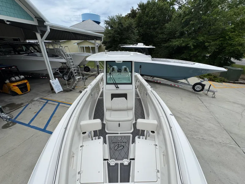 Slide: The Image of 2022 Sailfish 272 CC boat in a marina, surrounded by other boats and trees. - 21