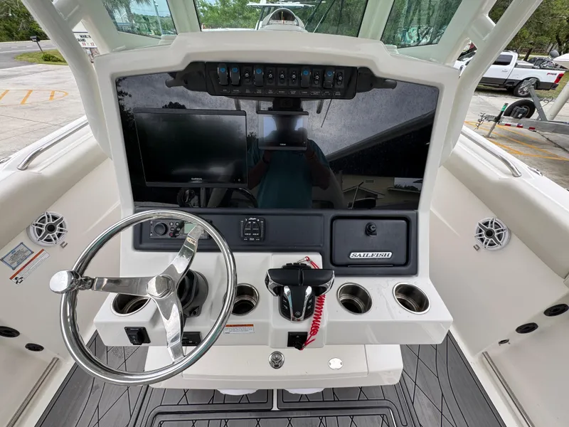 Slide: The Image of 2022 Sailfish 272 CC boat dashboard with steering wheel and control panel. - 28