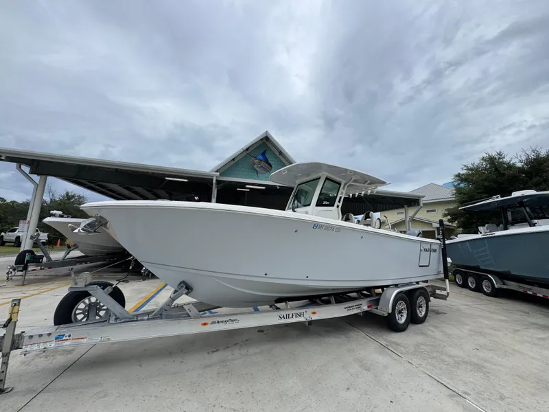 Slide: The Image of 2022 Sailfish 272 CC boat on trailer, parked outdoors under cloudy sky. - 3