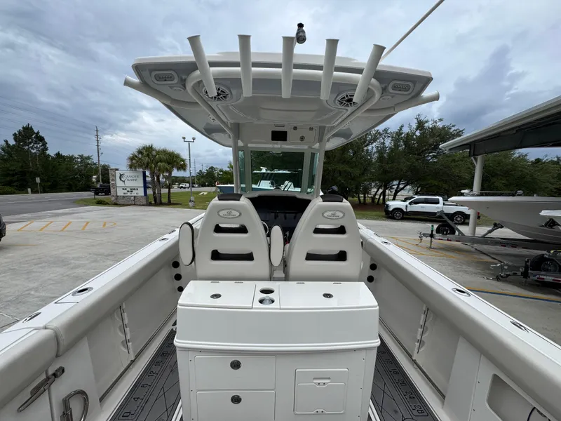 Slide: The Image of 2022 Sailfish 272 CC boat interior with dual seats and rod holders, parked outdoors. - 30