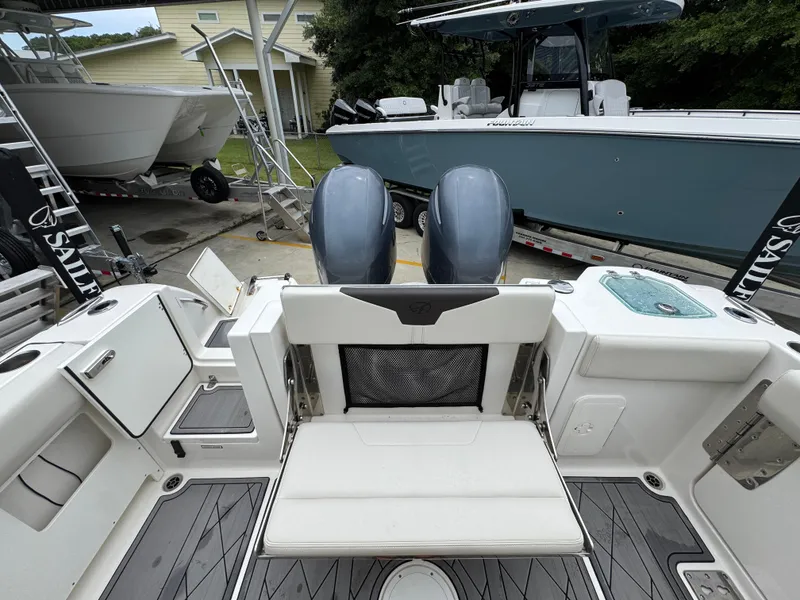 Slide: The Image of 2022 Sailfish 272 CC boat with dual engines and seating, parked near other boats. - 32