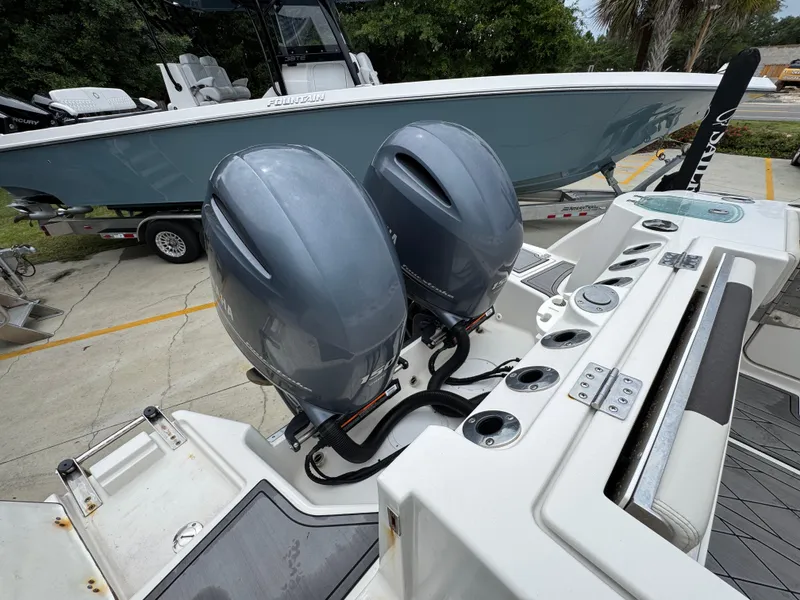 Slide: The Image of 2022 Sailfish 272 CC boat with dual outboard motors, docked beside another vessel. - 34