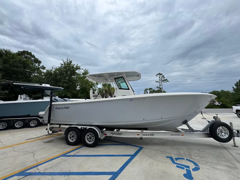 Slide: The Image of 2022 Sailfish 272 CC boat on trailer in parking lot, cloudy sky background. - 9