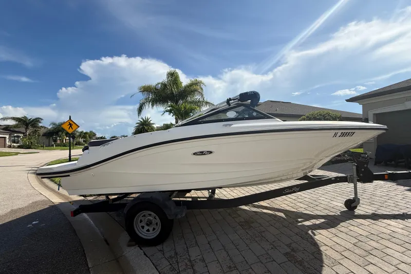 The Image of 2018 Sea Ray SPX 190 boat on trailer, parked in sunny residential area. - 0