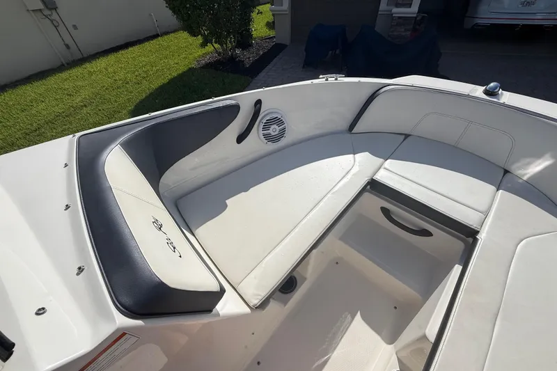 Slide: The Image of 2018 Sea Ray SPX 190 boat interior with cushioned seating and storage compartment. - 21