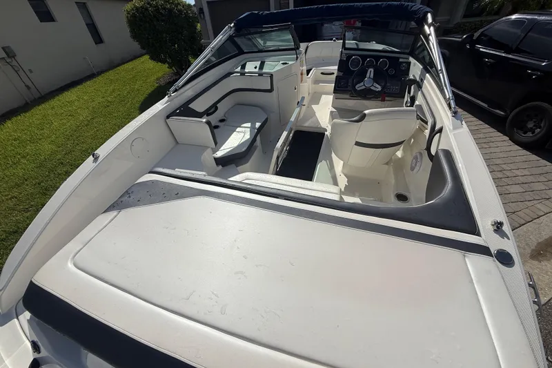 Slide: The Image of 2018 Sea Ray SPX 190 boat interior with seating and steering wheel, parked outdoors. - 25