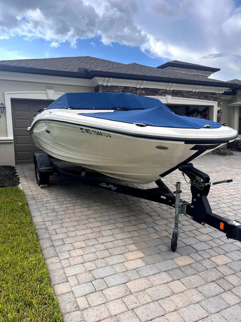 Slide: The Image of 2018 Sea Ray SPX 190 boat on trailer, parked in driveway, covered with blue tarp. - 28
