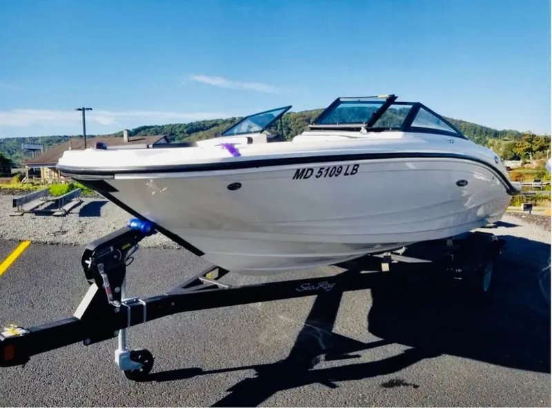 Slide: The Image of 2018 Sea Ray SPX 190 boat on trailer, parked outdoors under clear blue sky. - 3
