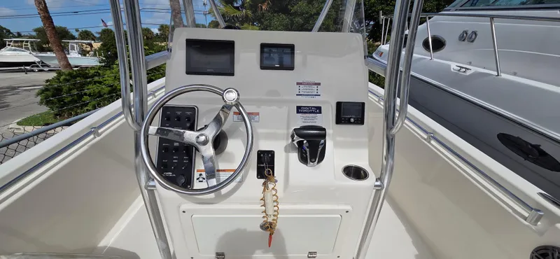 Slide: The Image of 2023 Cobia 220 Center Console boat dashboard with steering wheel and controls. - 13