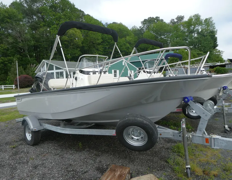 Slide: The Image of 2025 Boston Whaler 170 Montauk boat on trailer, parked outdoors with trees in background. - 1