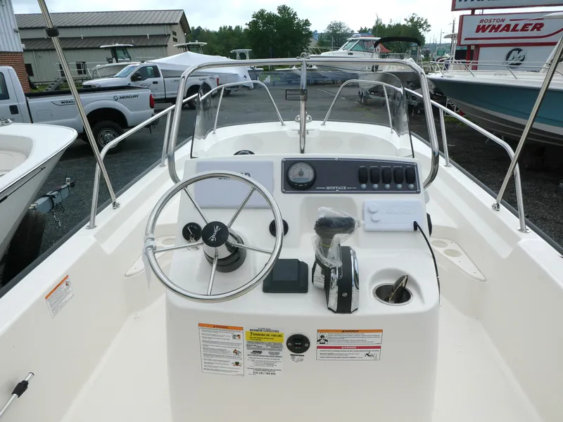 Slide: The Image of 2025 Boston Whaler 170 Montauk boat dashboard with steering wheel and controls. - 4