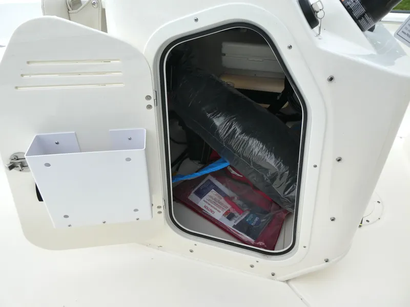 Slide: The Image of Open storage compartment on 2025 Boston Whaler 170 Montauk boat, showing interior contents. - 6