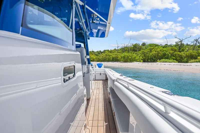Slide: The Image of 2020 HCB 53 boat docked near a sandy beach with clear blue water. - 14