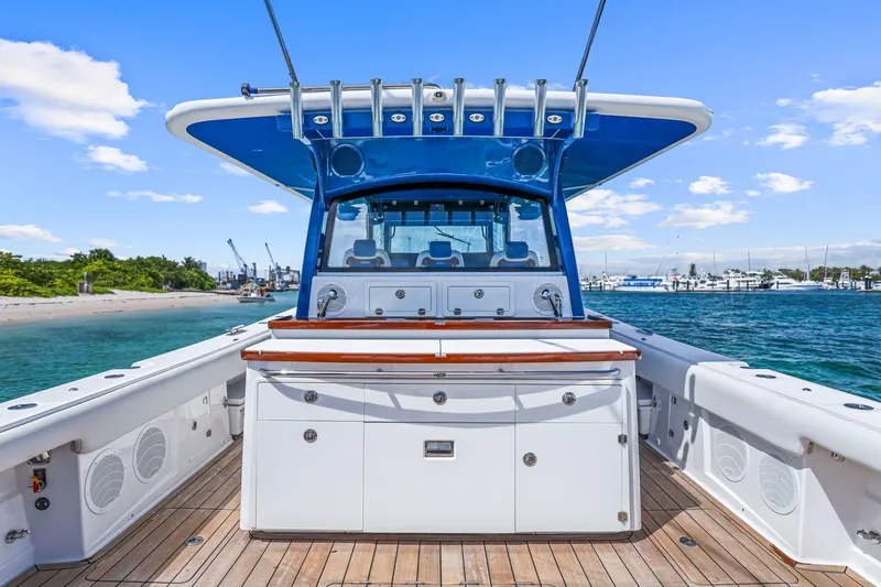 Slide: The Image of 2020 HCB 53 boat with spacious deck, docked near a scenic shoreline. - 22