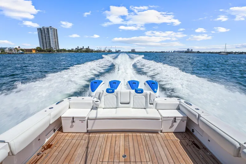 Slide: The Image of 2020 HCB 53 boat cruising on open water with city skyline in background. - 31