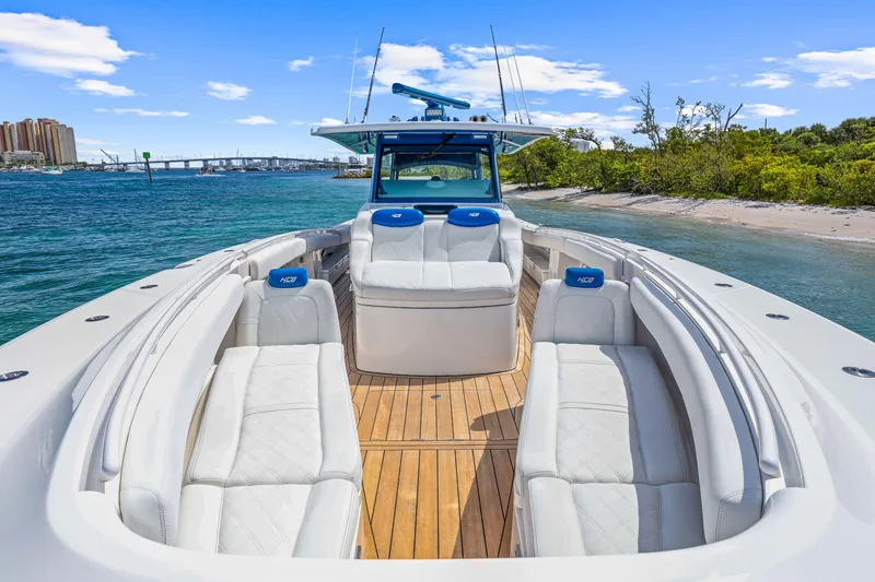 Slide: The Image of Luxurious 2020 HCB 53 boat with spacious seating, docked near a scenic shoreline. - 34