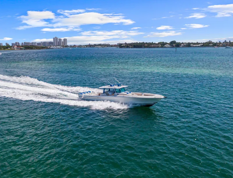 Slide: The Image of 2020 HCB 53 boat cruising on blue water with city skyline in background. - 45