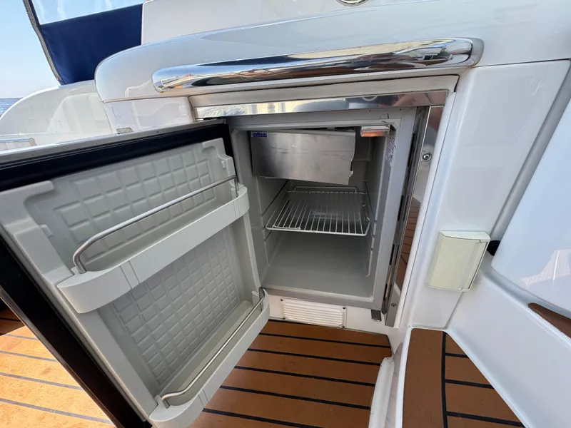 Slide: The Image of Open mini fridge on 2008 Formula 40 PC yacht, showcasing interior shelves and sleek design. - 13