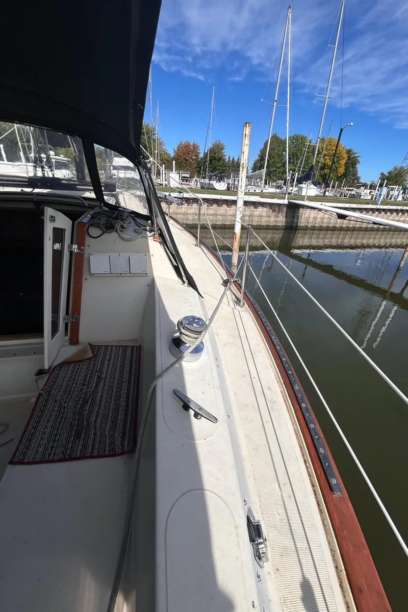 Slide: The Image of 1982 S2 11.0 A sailboat docked at marina, clear sky, calm water. - 12