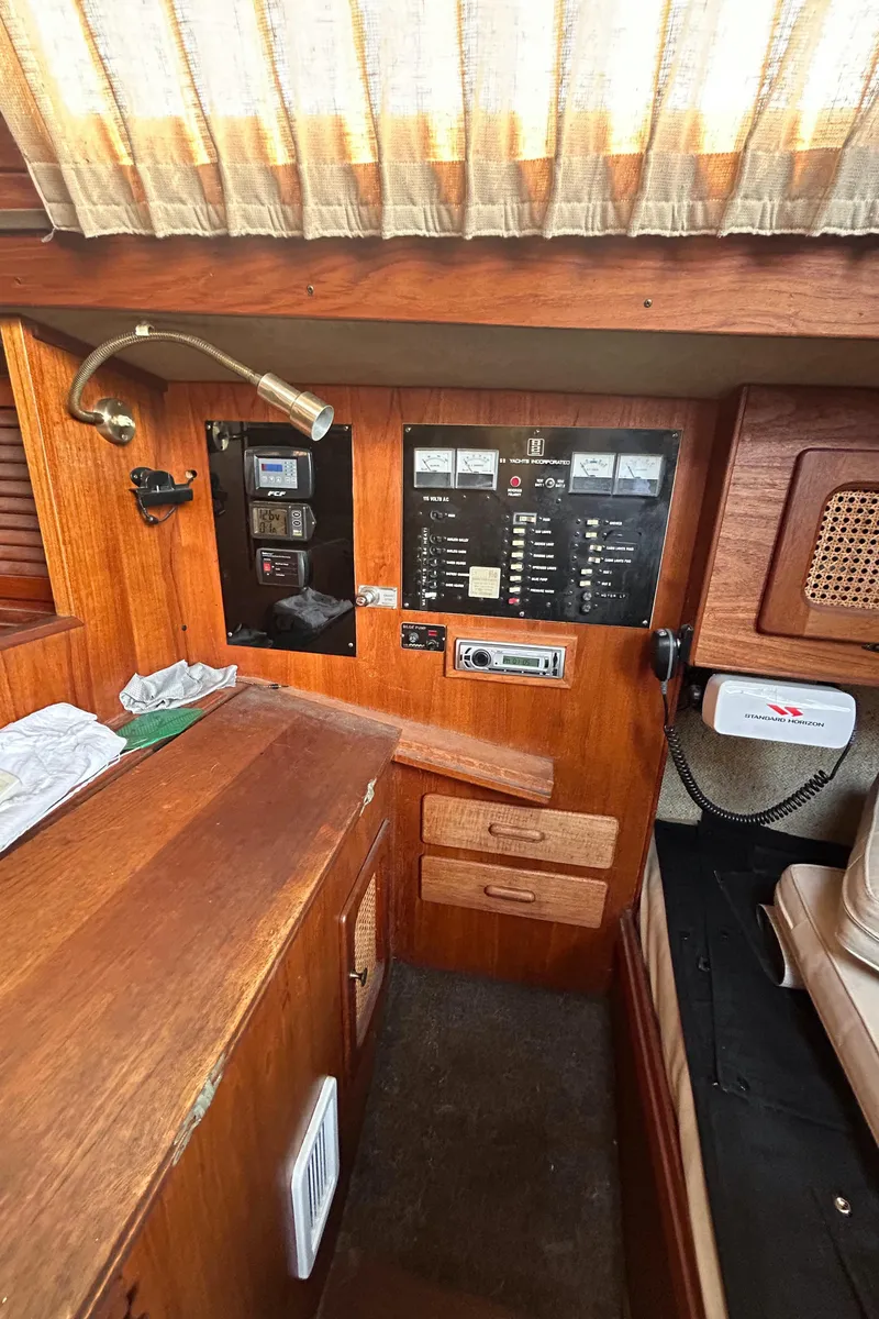 Slide: The Image of 1982 S2 11.0 A sailboat interior with control panel and wooden cabinetry. - 17