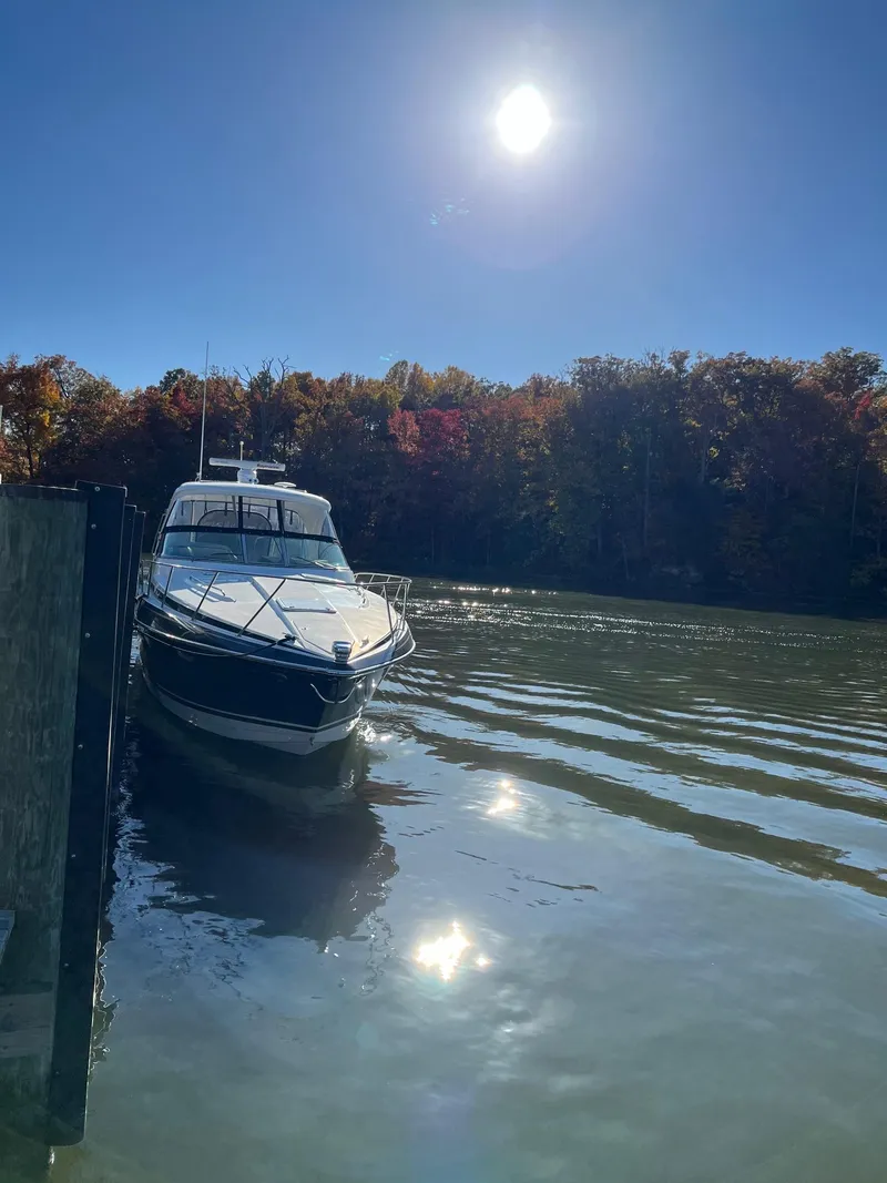 Slide: The Image of 2016 Formula 37 PC boat docked on a sunny day with autumn trees in the background. - 2