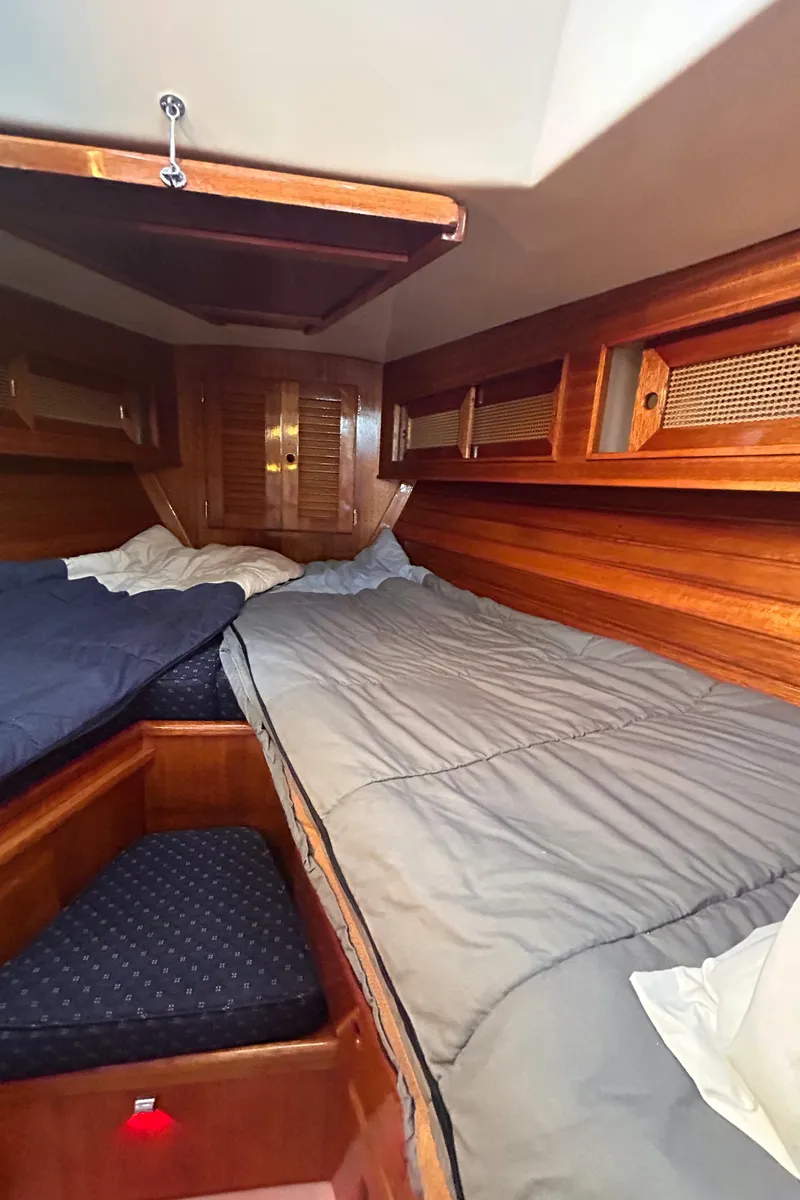 Slide: The Image of Cozy cabin interior of 1980 Bristol 35.5 sailboat with wooden paneling and bedding. - 11