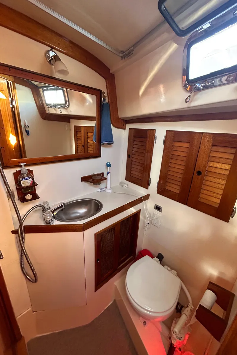 Slide: The Image of 1980 Bristol 35.5 yacht bathroom with sink, mirror, and wooden cabinets. - 12