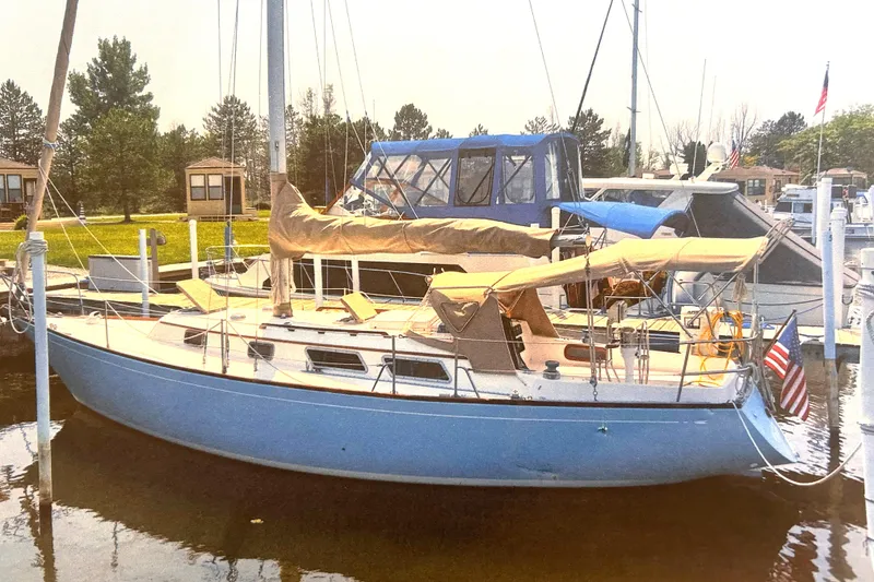 Slide: The Image of 1980 Bristol 35.5 sailboat docked in a marina, featuring a blue hull and tan covers. - 5