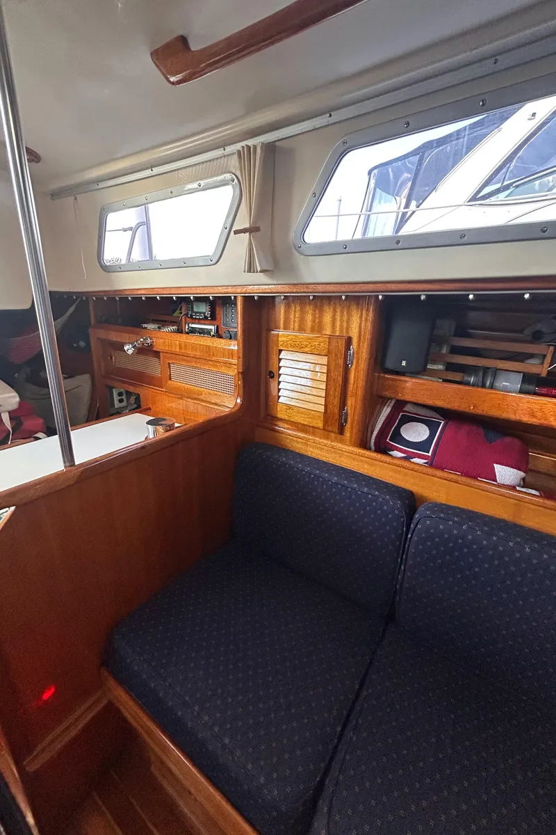 Slide: The Image of Interior of 1980 Bristol 35.5 sailboat with wooden cabinetry and blue seating. - 6