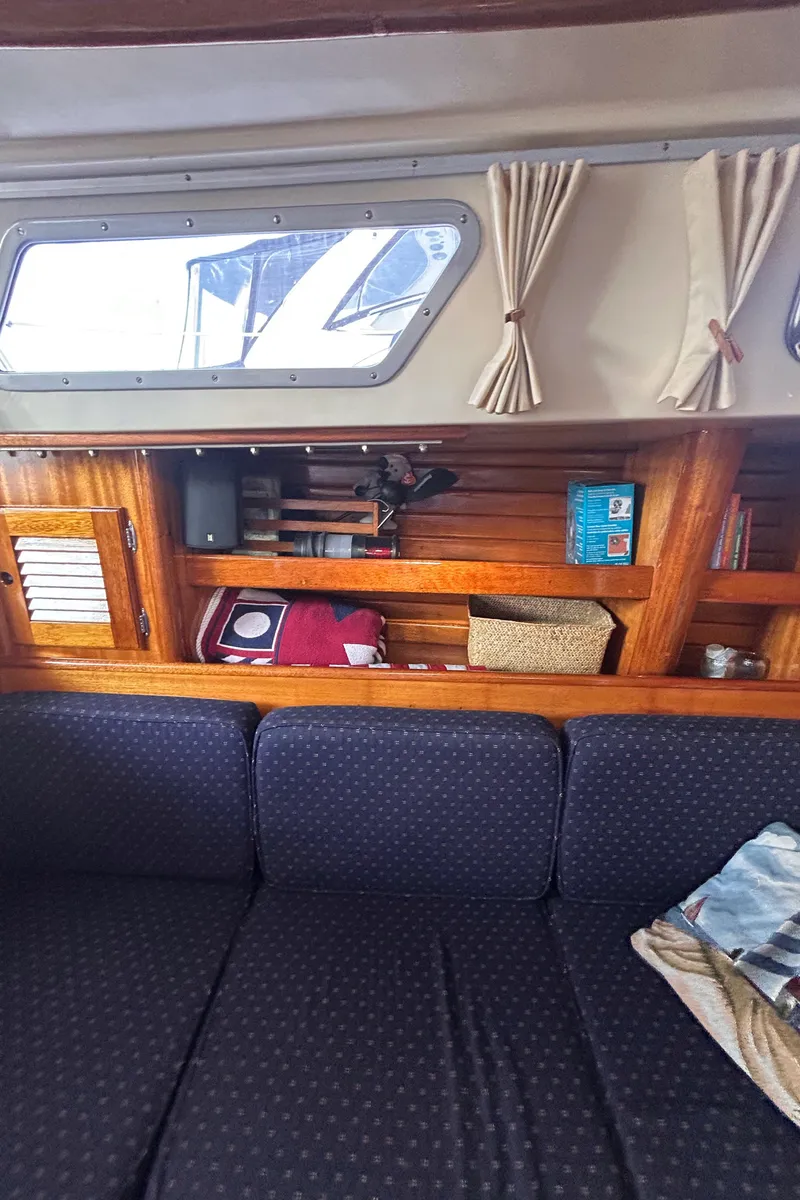 Slide: The Image of Interior of 1980 Bristol 35.5 sailboat with wooden shelves and navy blue sofa. - 7