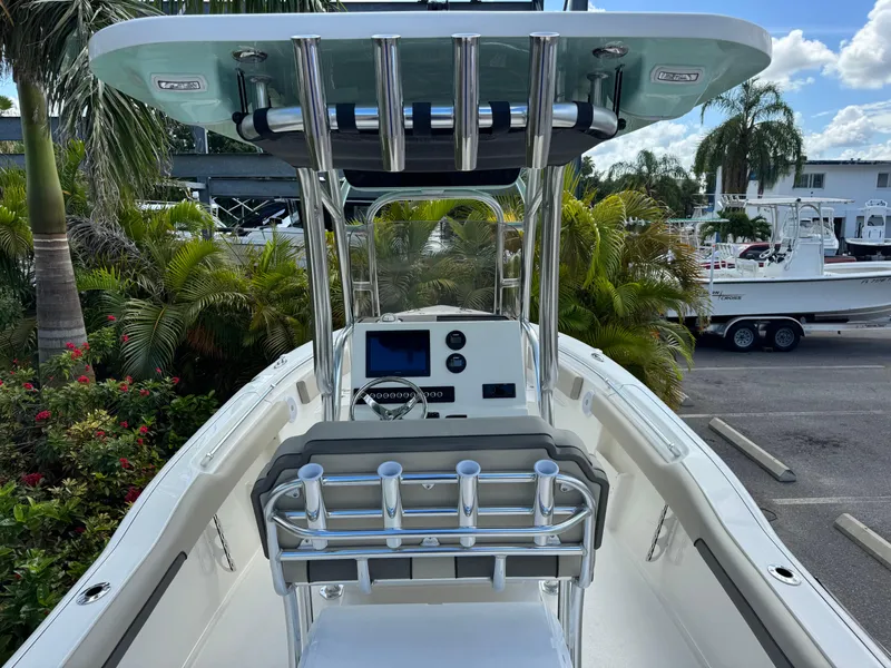 Slide: The Image of 2025 Key West 239 FS boat with sleek console and rod holders, surrounded by lush greenery. - 12