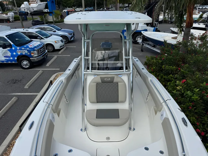 Slide: The Image of 2025 Key West 239 FS boat, sleek design, parked in a marina with surrounding greenery. - 22