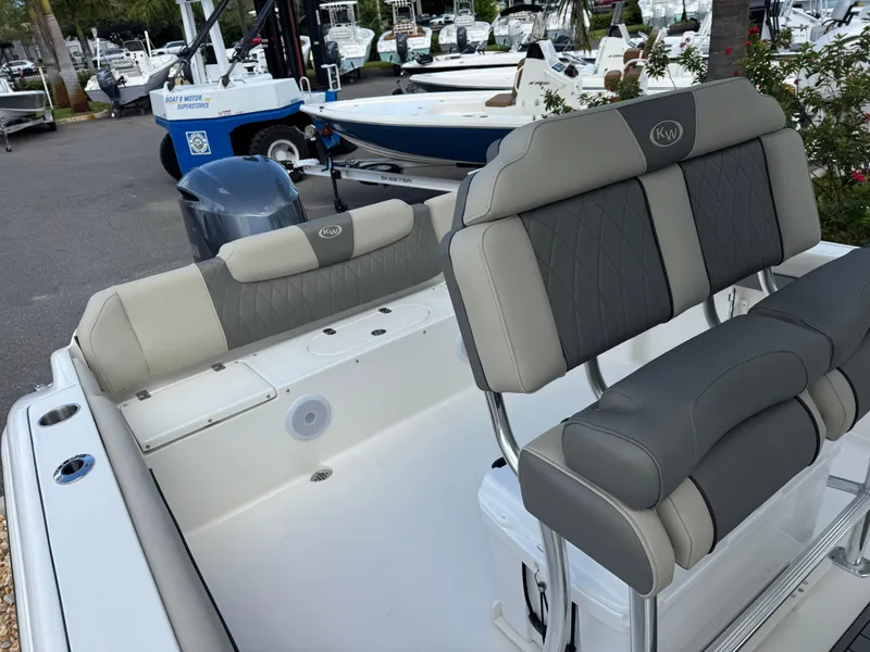 Slide: The Image of 2025 Key West 239 FS boat interior with cushioned seating and motor in marina setting. - 27