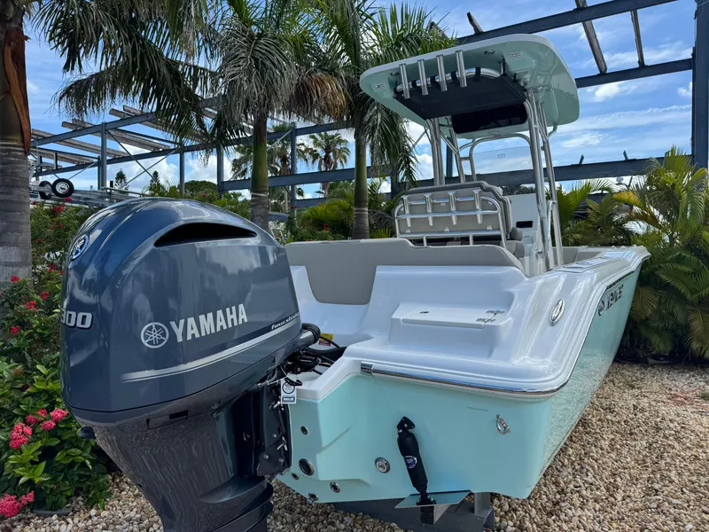 Slide: The Image of 2025 Key West 239 FS boat with Yamaha engine, parked among tropical plants. - 6